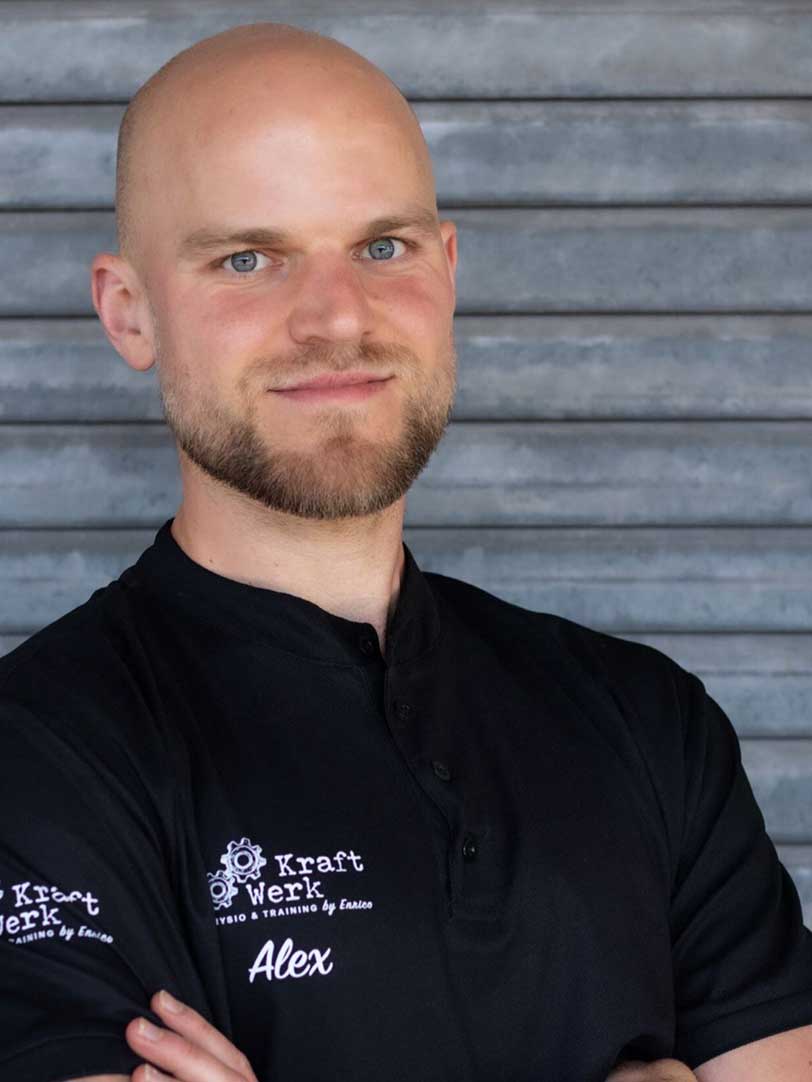 Mann mit Glatze und Bart, lächelt selbstbewusst, trägt schwarzes T-Shirt.