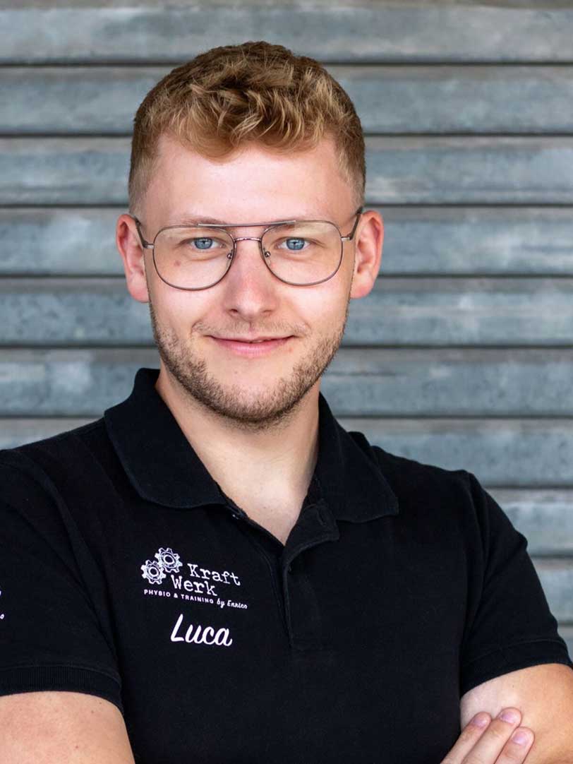 Mann mit Brille im schwarzen Poloshirt lächelt vor grauem Hintergrund